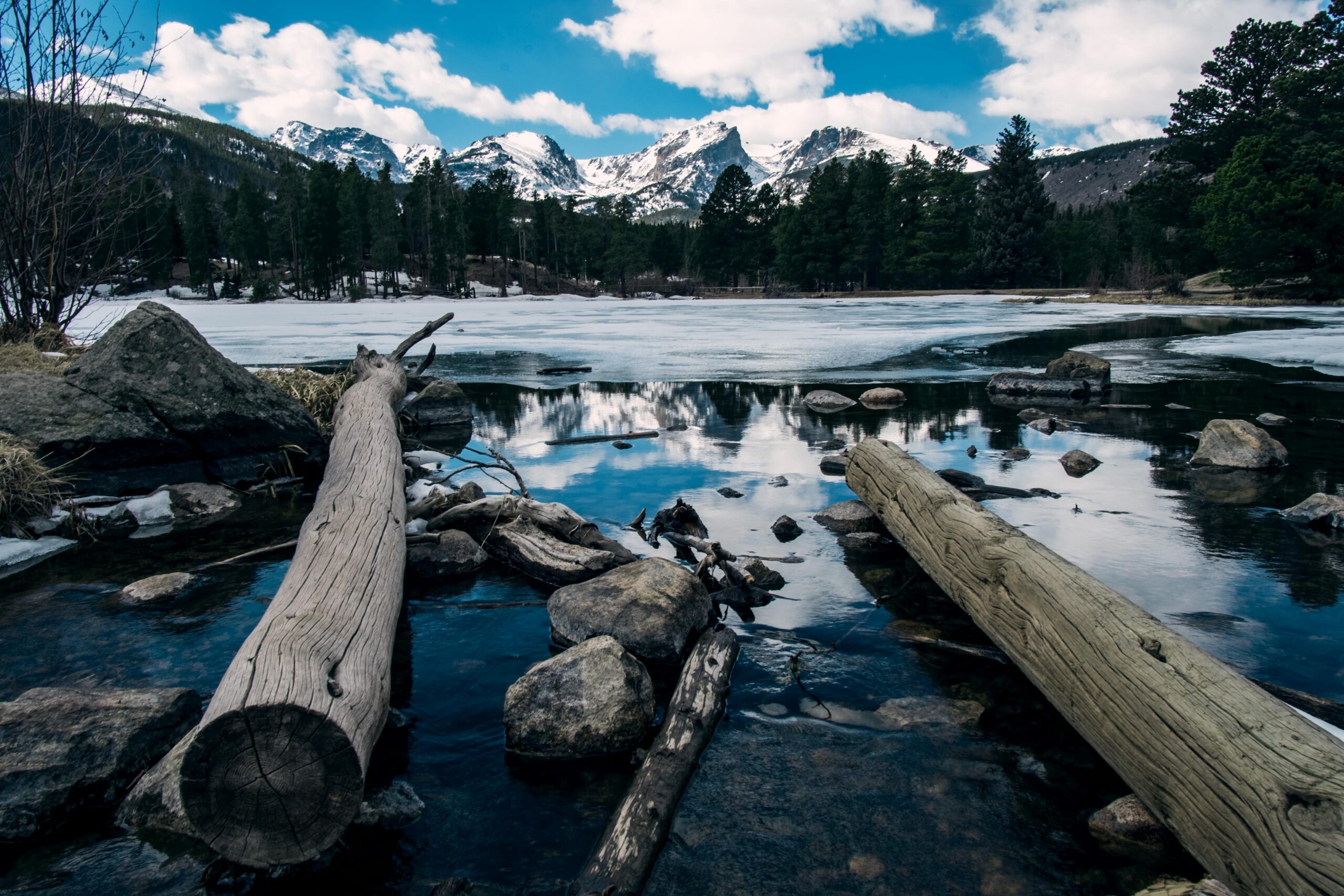 Tranquil winter scene of snowy mountains and icy lake in Estes Park, Colorado.